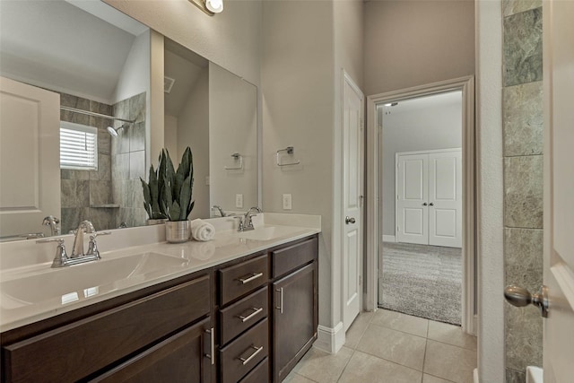 full bath featuring tile patterned flooring, double vanity, a tile shower, and a sink