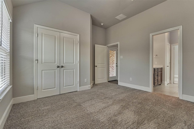 unfurnished bedroom with carpet, baseboards, and a closet