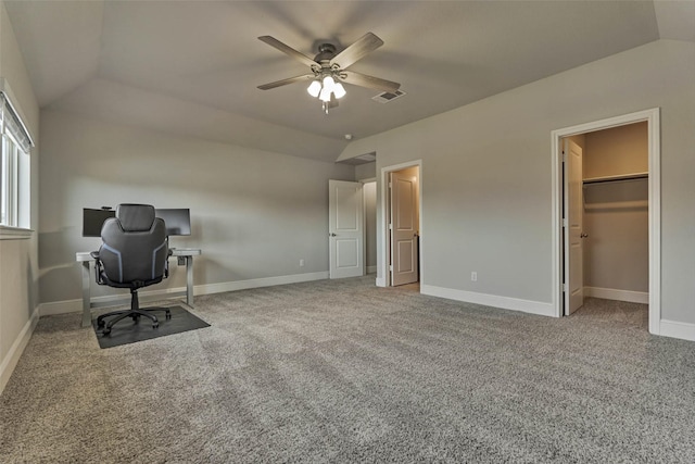 unfurnished office featuring visible vents, baseboards, carpet floors, vaulted ceiling, and a ceiling fan