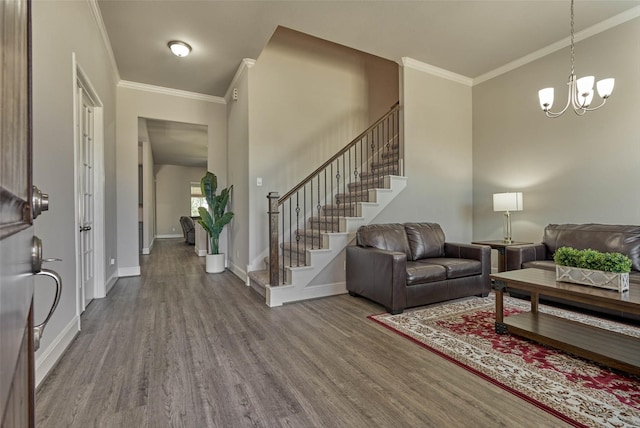 foyer featuring baseboards, stairway, ornamental molding, wood finished floors, and a notable chandelier