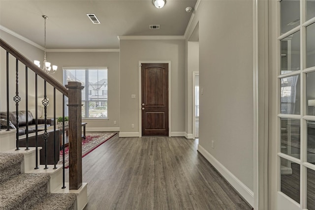 foyer entrance featuring dark wood-type flooring, stairway, a notable chandelier, and visible vents