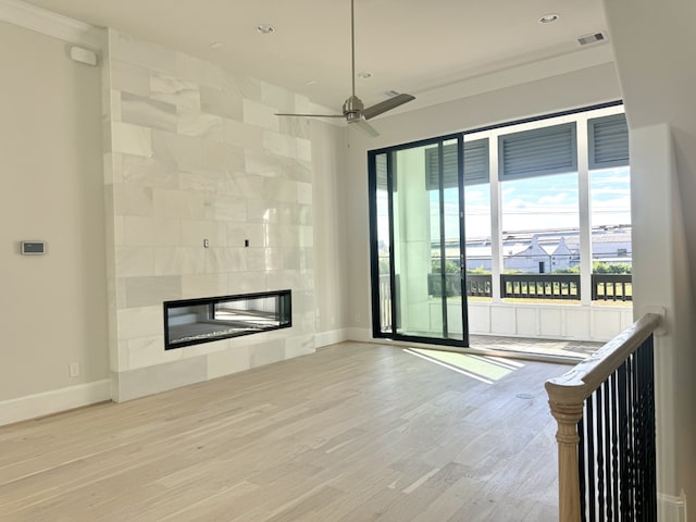 unfurnished living room with wood finished floors, a fireplace, visible vents, and baseboards