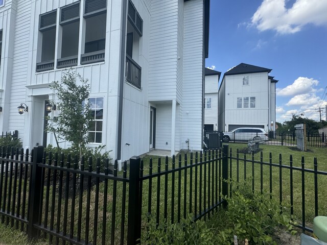 view of side of home with a yard, fence private yard, and board and batten siding