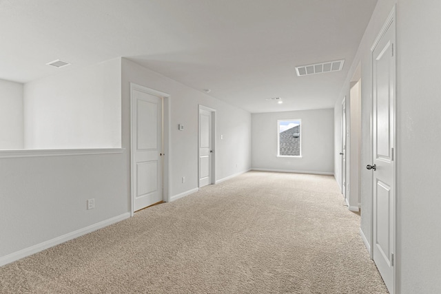 carpeted spare room with visible vents and baseboards