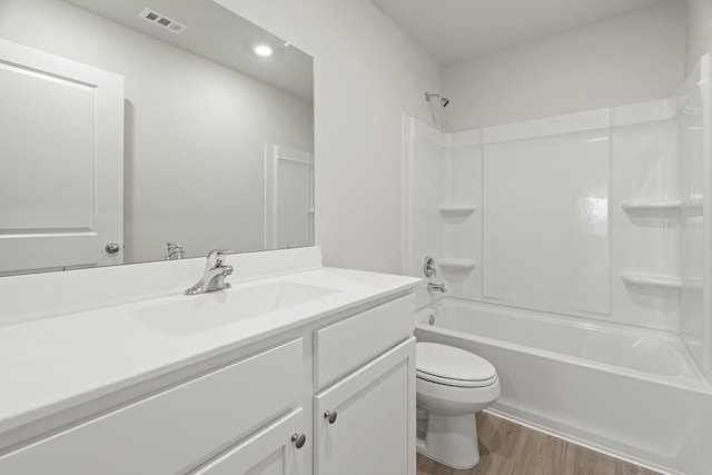 full bath with visible vents, toilet, wood finished floors, bathtub / shower combination, and vanity