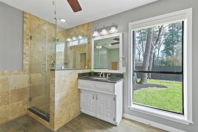 bathroom with a shower stall, a healthy amount of sunlight, and ceiling fan