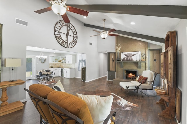 living room featuring visible vents, ceiling fan with notable chandelier, a fireplace, and wood finished floors