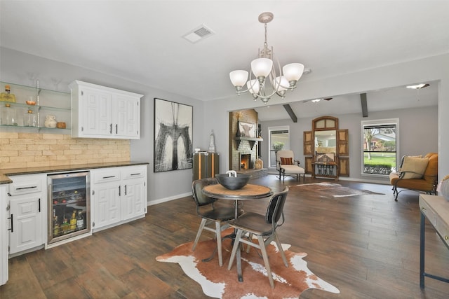 dining area with visible vents, baseboards, wine cooler, dark wood finished floors, and a notable chandelier