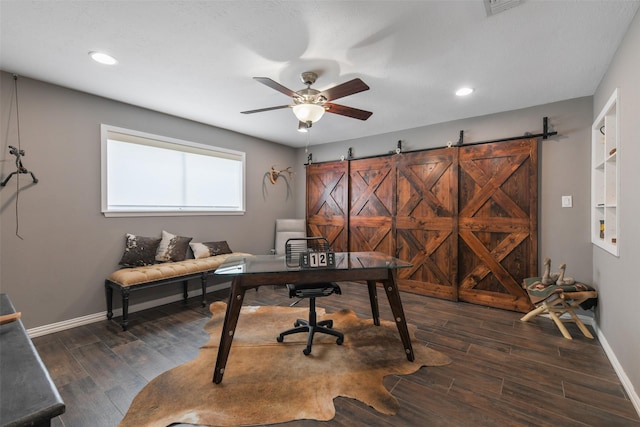 office space featuring dark wood-style floors, baseboards, and a barn door