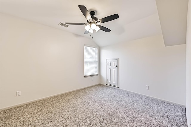 spare room featuring visible vents, a ceiling fan, baseboards, light colored carpet, and vaulted ceiling