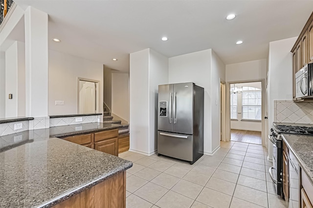 kitchen with light tile patterned floors, decorative backsplash, dark stone countertops, recessed lighting, and stainless steel appliances