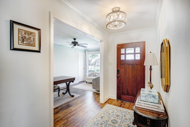 foyer featuring baseboards, wood finished floors, ornamental molding, and ceiling fan with notable chandelier