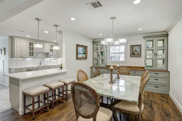 dining room featuring a notable chandelier, visible vents, dark wood-style flooring, and ornamental molding