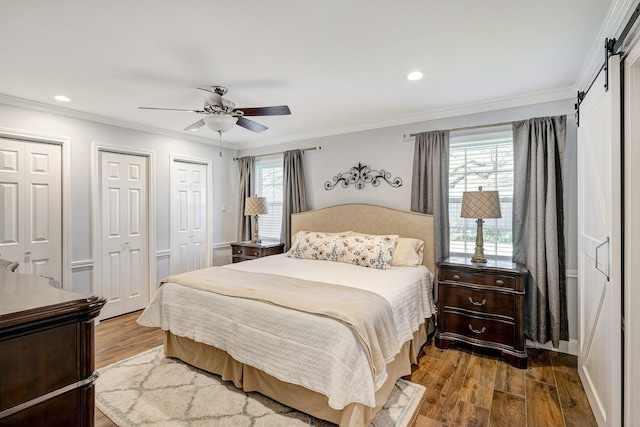 bedroom featuring multiple windows, wood finished floors, and crown molding