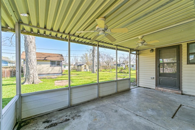 unfurnished sunroom with ceiling fan