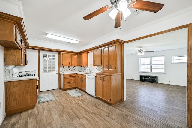 kitchen with backsplash, white appliances, brown cabinetry, light countertops, and ceiling fan