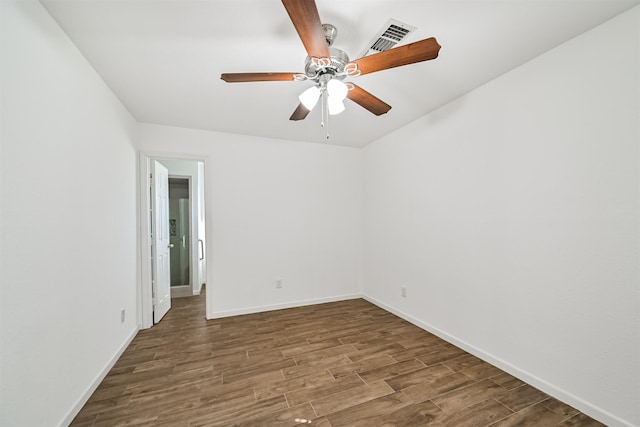 empty room with visible vents, baseboards, wood finished floors, and a ceiling fan