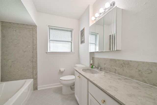 bathroom featuring vanity, baseboards, tile patterned floors, toilet, and a bathtub