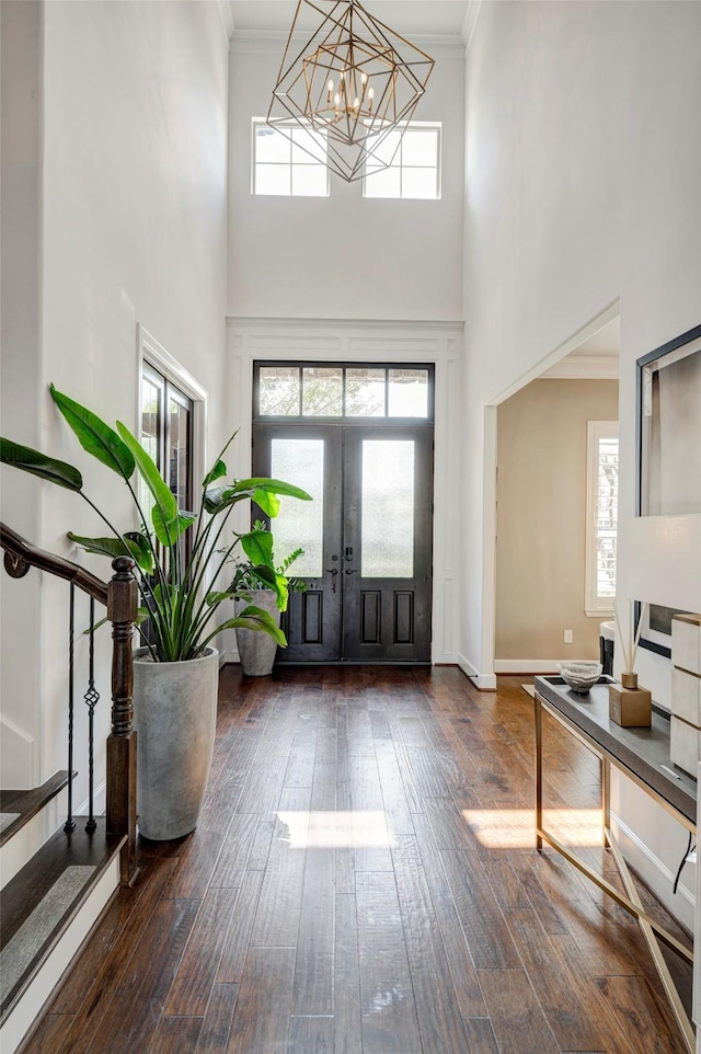 entrance foyer with stairs, crown molding, and dark wood-style flooring