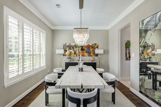 dining area featuring visible vents, a notable chandelier, dark wood finished floors, and ornamental molding