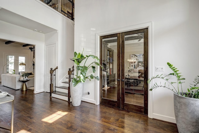 foyer entrance featuring stairs, a ceiling fan, baseboards, and wood-type flooring