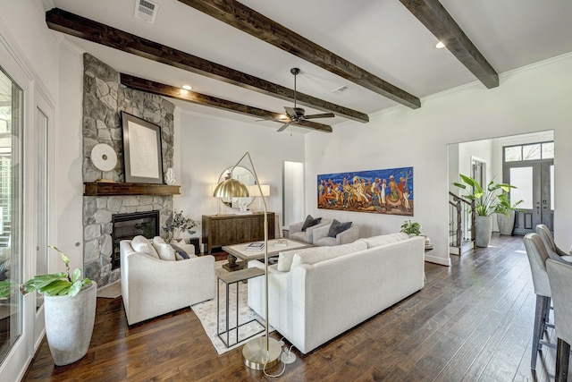 living area with visible vents, a fireplace, ceiling fan, dark wood-type flooring, and beamed ceiling