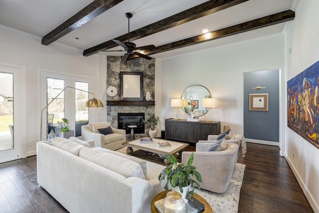 living area with a stone fireplace, dark wood-style floors, baseboards, and a ceiling fan