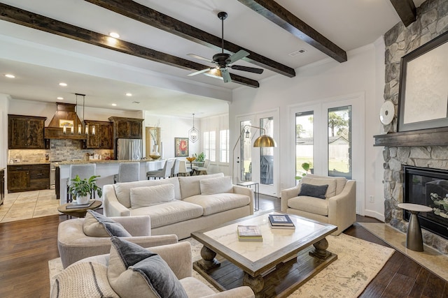 living area featuring a fireplace, light wood-style floors, visible vents, and ceiling fan