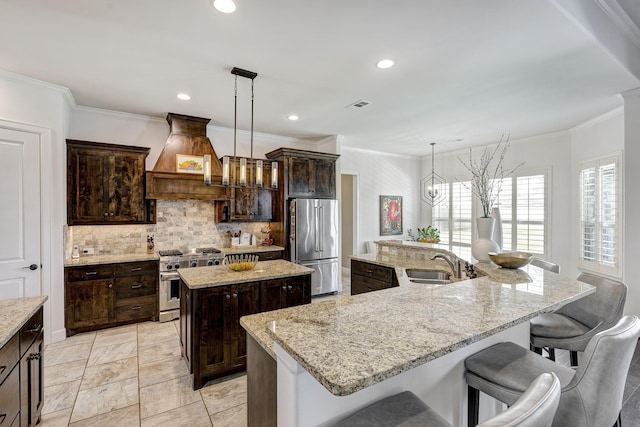 kitchen featuring visible vents, premium range hood, high quality appliances, decorative backsplash, and a large island with sink