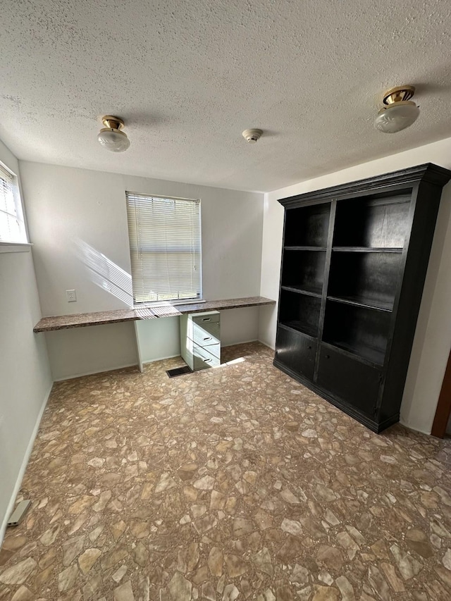 unfurnished bedroom with baseboards and a textured ceiling