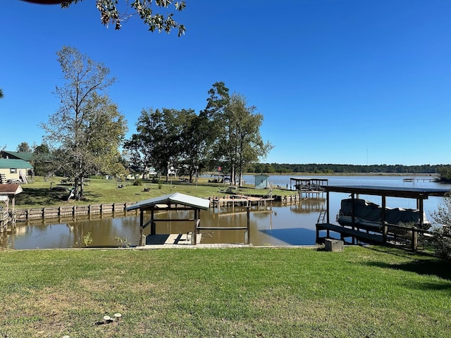 dock area with a lawn and a water view