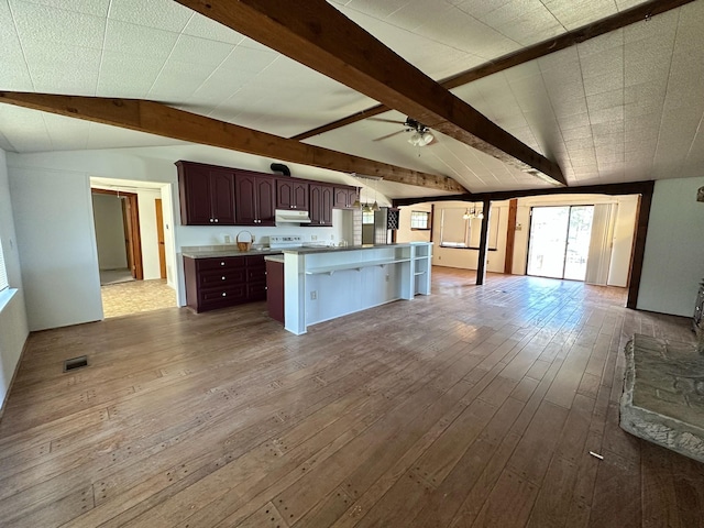 kitchen featuring hardwood / wood-style floors, vaulted ceiling with beams, and ceiling fan