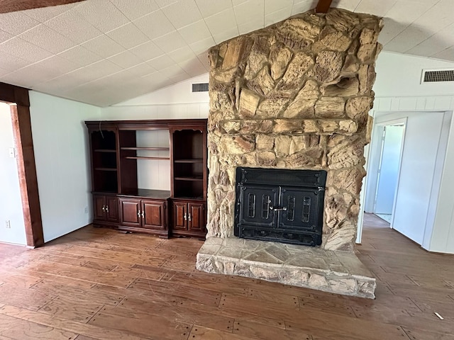 unfurnished living room featuring visible vents, lofted ceiling, and hardwood / wood-style floors