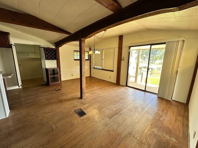 interior space featuring hardwood / wood-style floors, vaulted ceiling with beams, visible vents, and a chandelier