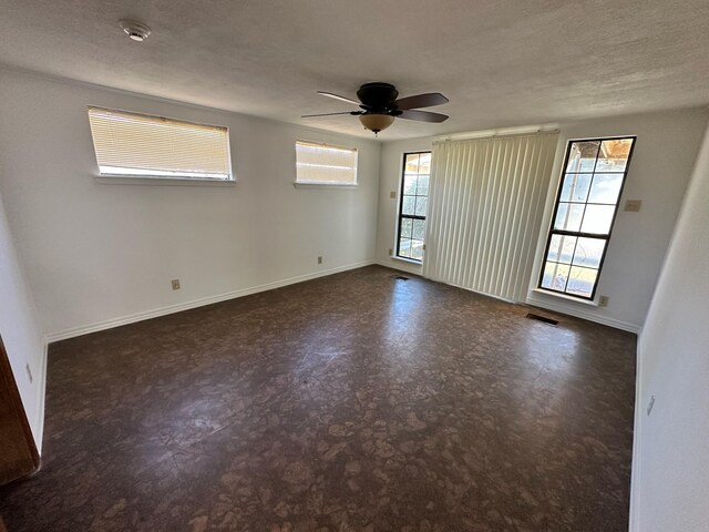 empty room with visible vents, baseboards, ceiling fan, a textured ceiling, and tile patterned floors