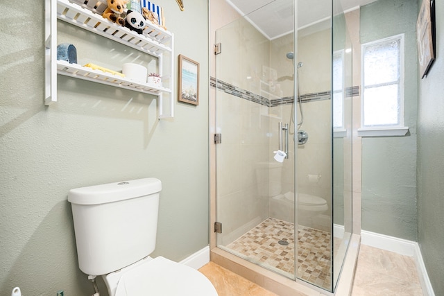 full bath featuring toilet, baseboards, and a stall shower