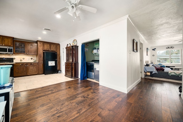 kitchen with stainless steel microwave, visible vents, ceiling fan, light wood-style flooring, and freestanding refrigerator