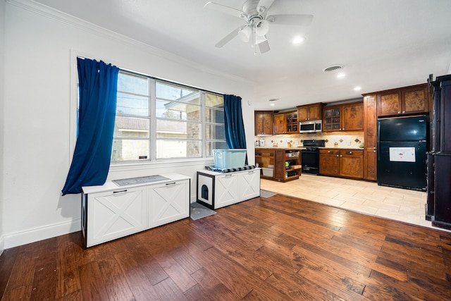 kitchen featuring a ceiling fan, visible vents, black appliances, crown molding, and light wood-type flooring