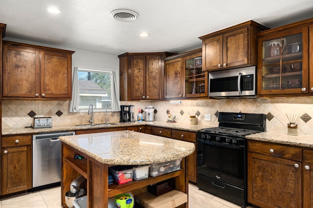 kitchen featuring light tile patterned floors, visible vents, open shelves, a sink, and appliances with stainless steel finishes