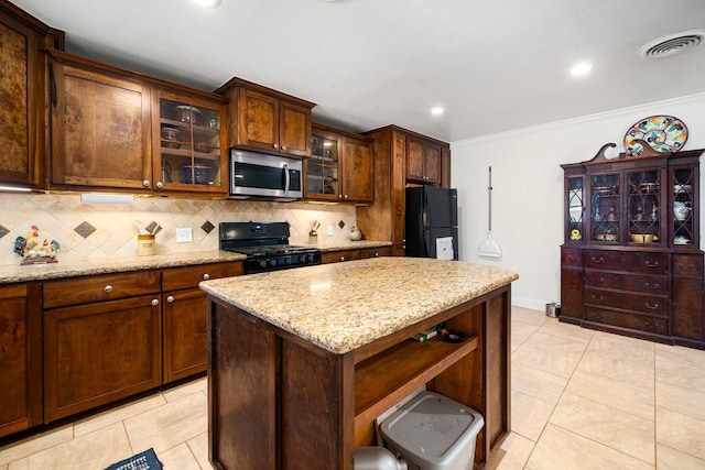 kitchen with visible vents, black appliances, ornamental molding, backsplash, and light stone countertops