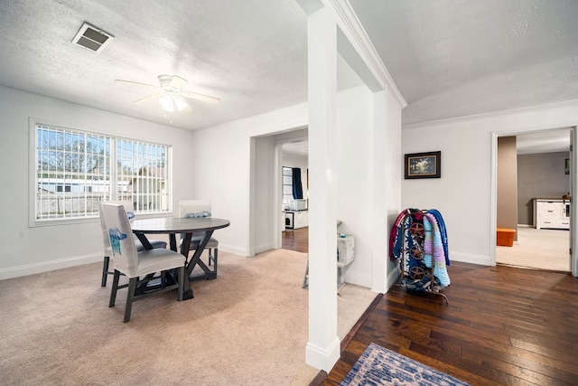 carpeted dining room featuring visible vents, baseboards, a textured ceiling, and a ceiling fan