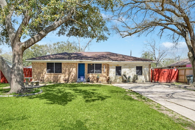 ranch-style house featuring driveway, a front yard, and fence