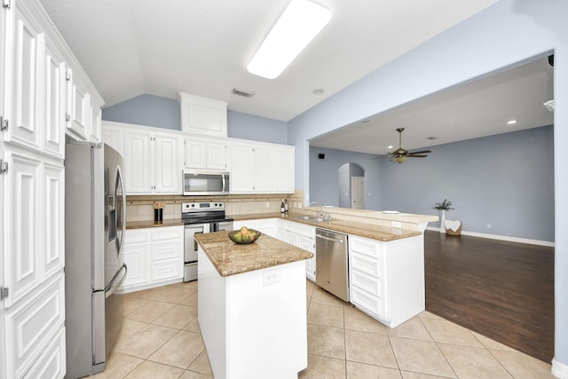 kitchen featuring visible vents, a sink, stainless steel appliances, a peninsula, and light tile patterned flooring