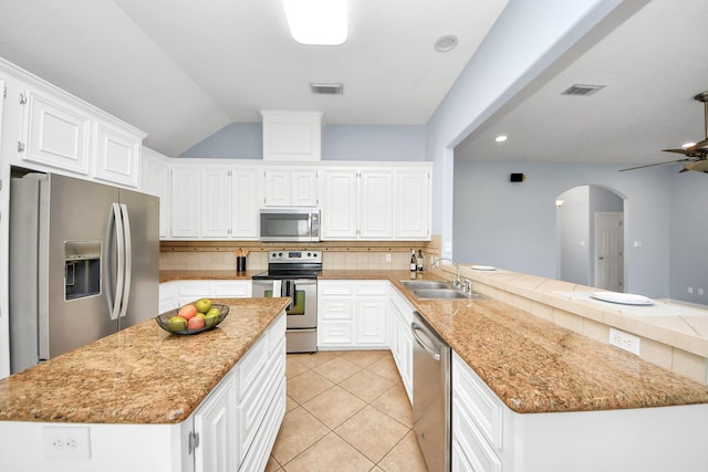 kitchen featuring visible vents, backsplash, appliances with stainless steel finishes, a peninsula, and a sink