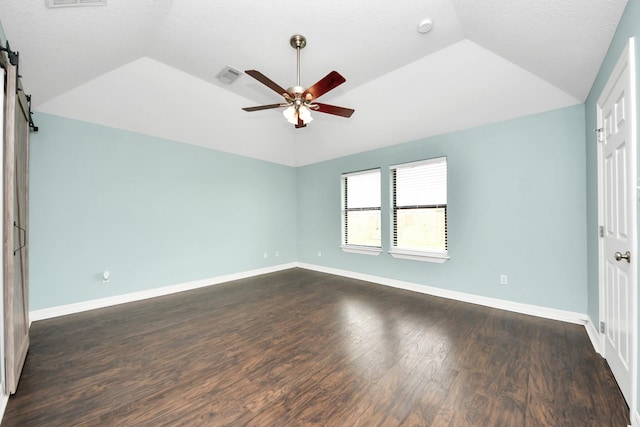 unfurnished room featuring a ceiling fan, visible vents, baseboards, lofted ceiling, and dark wood-style flooring