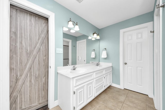 bathroom with tile patterned floors, double vanity, baseboards, and a sink