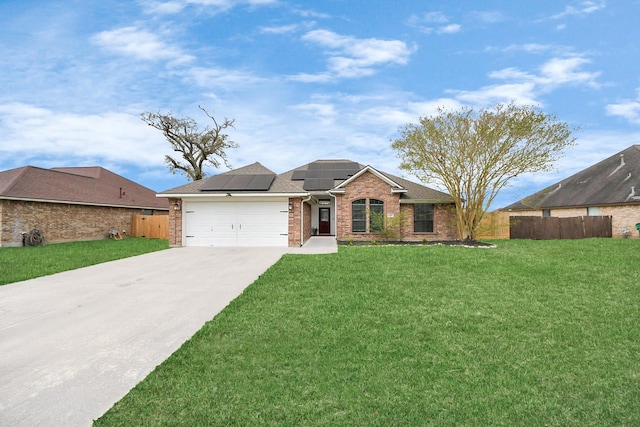 ranch-style house with driveway, fence, a front yard, a garage, and solar panels