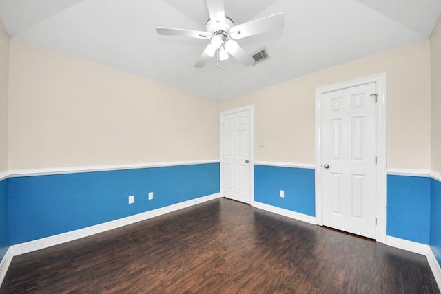 spare room featuring visible vents, baseboards, a ceiling fan, and dark wood-style flooring