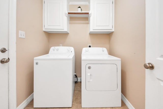 washroom with washer and clothes dryer, light tile patterned floors, cabinet space, and baseboards