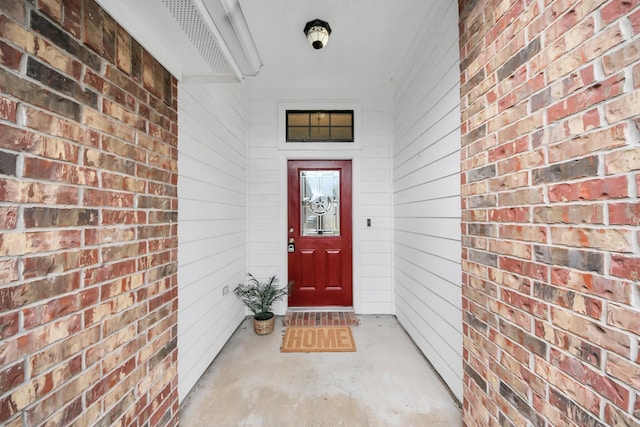 view of exterior entry featuring brick siding